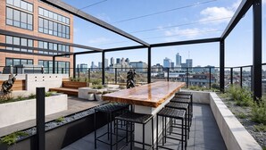 Une terrasse sur le toit avec un bar en bois, des sièges et une vue sur la ville.