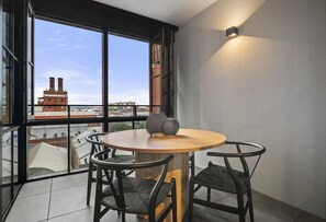 Enjoy a panoramic city view from this stylish room with a large window, round table, and minimalist decor.