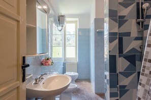 A bathroom with a sink, toilet, and shower.