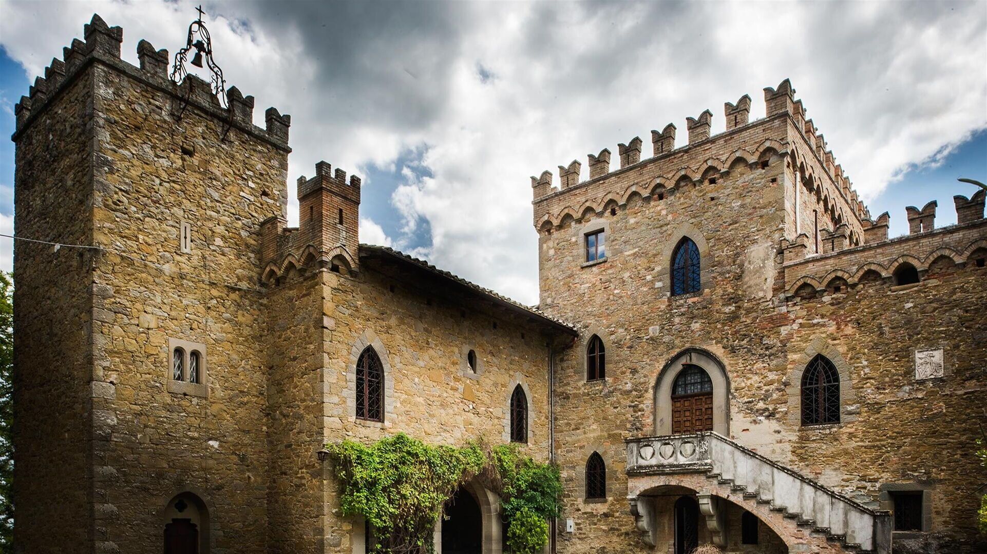 A historic stone building with arched windows and a bell tower.