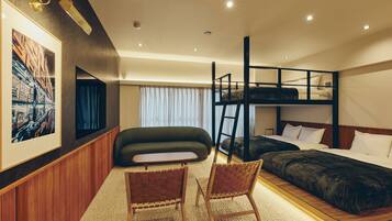 A bunk bed room with a ladder, a sofa, two chairs, and a framed picture on the wall.