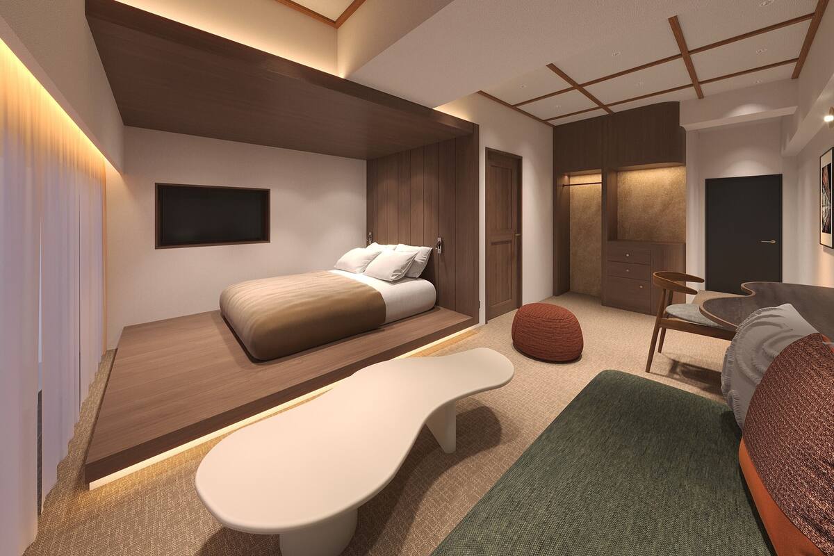 A modern interior with a bed, seating area, and a small table.