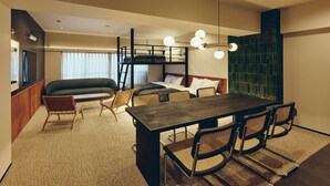 A compact hotel room with bunk beds, a dining table with chairs, a sofa, and a television. - illi Tas Shinjuku (Tokyo)