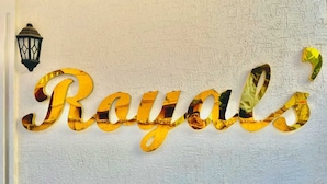 Una pared con la palabra 'Royals' en letras doradas grandes y reflectantes.