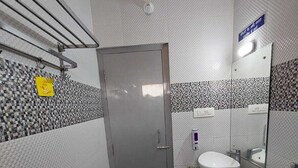 A small bathroom with a single sink, a toilet, and a mirror.
