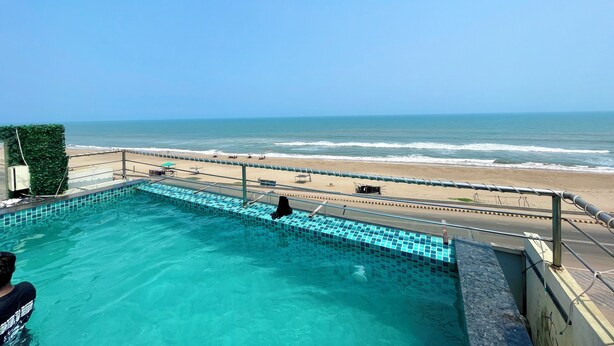 A swimming pool with a view of the beach and ocean. - TBS Sea View - Full AC- Pool & Breakfast (Puri)