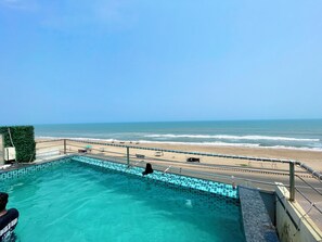 Ein Schwimmbad mit Blick auf Strand und Meer.
