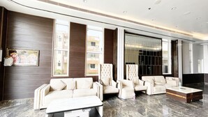 A modern living room with a sofa, armchairs, and a coffee table. - TBS Sea View - Full AC- Pool & Breakfast (Puri)