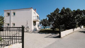 A two-story building with a balcony, a gated entrance, and a view of the sea. - Villa Maia in Rhodes (Rhodes)