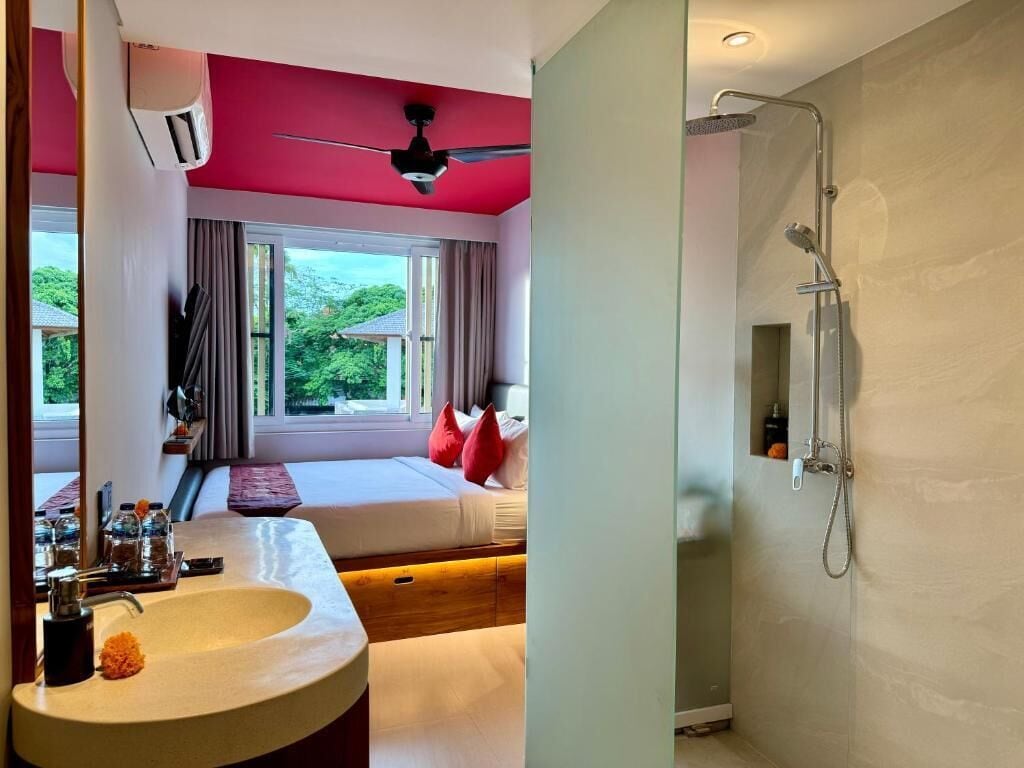 A modern bedroom with a large bed, a built-in sink, and a shower.