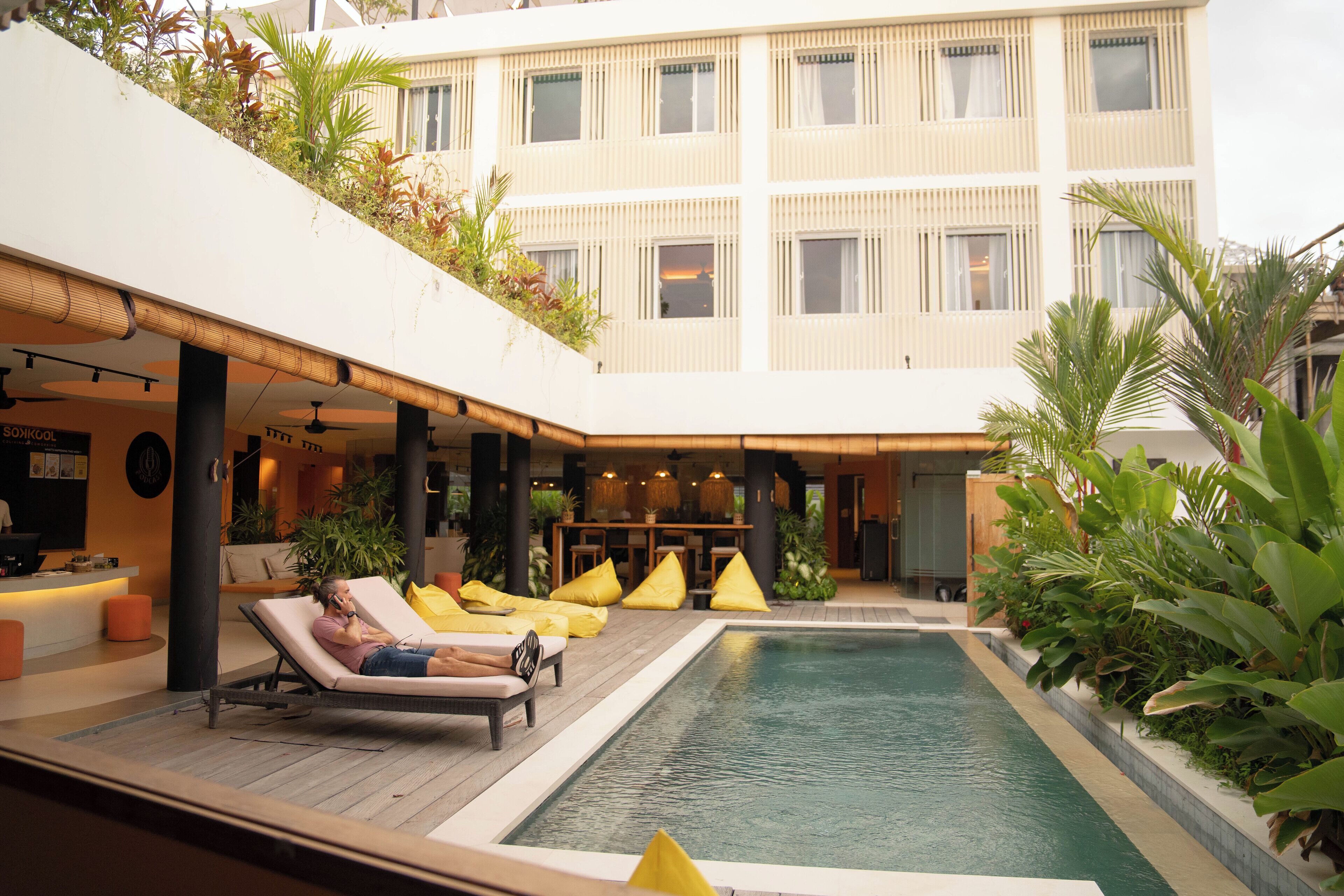 A pool area with lounge chairs and a bar.