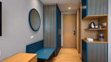 Un interior moderno con un banco, una puerta y una estantería con objetos.