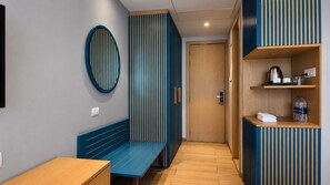 Un interior moderno con un banco, una puerta y una estantería con objetos.