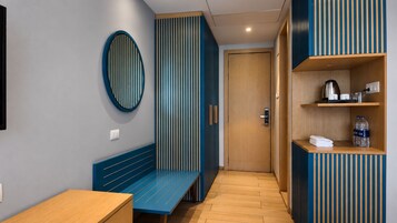 Un interior moderno con un banco, una puerta y una estantería con objetos.
