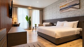 Une chambre d’hôtel moderne, dotée d’un grand lit, d’un bureau et d’une télévision.