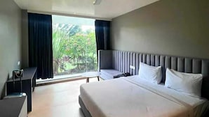 A modern hotel room with a large bed, a desk, and a chair. - THE DEMOCRACY HOTEL & RESORT (Nashik)