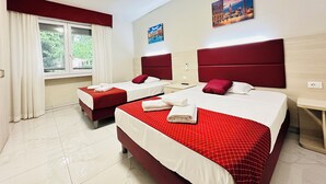 A hotel room with two beds, red bedding, a window with curtains, and artwork on the walls. - Dream Hub (Mestre)