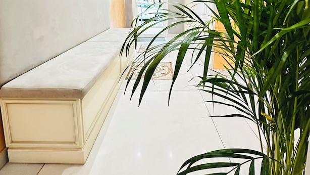 A hallway with a white bench, a potted plant, and a view into another room. - Dream Hub (Mestre)