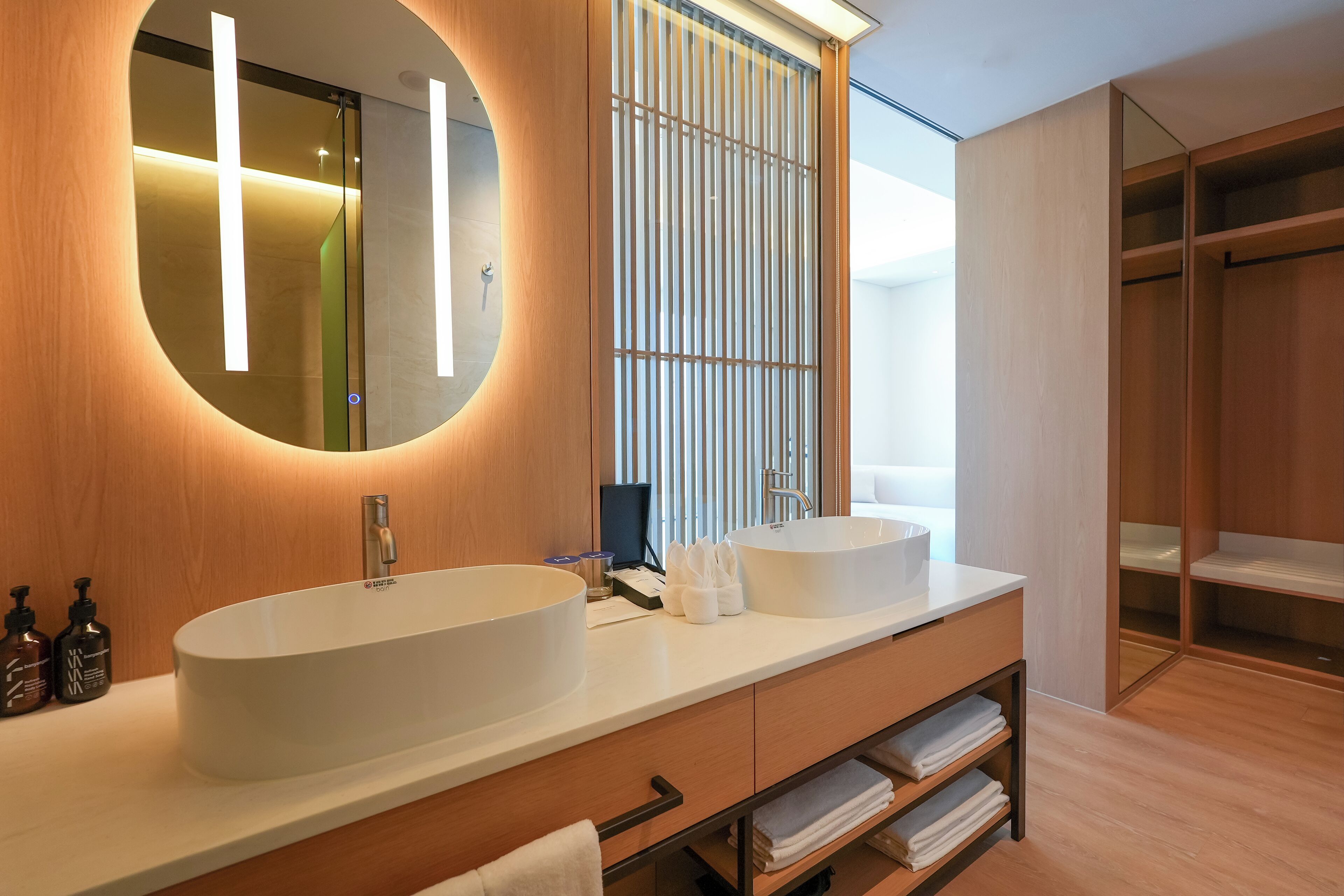Ein modernes Badezimmer mit einem großen, ovalen Waschbecken, einem Spiegel und einer bodenebenen Dusche.