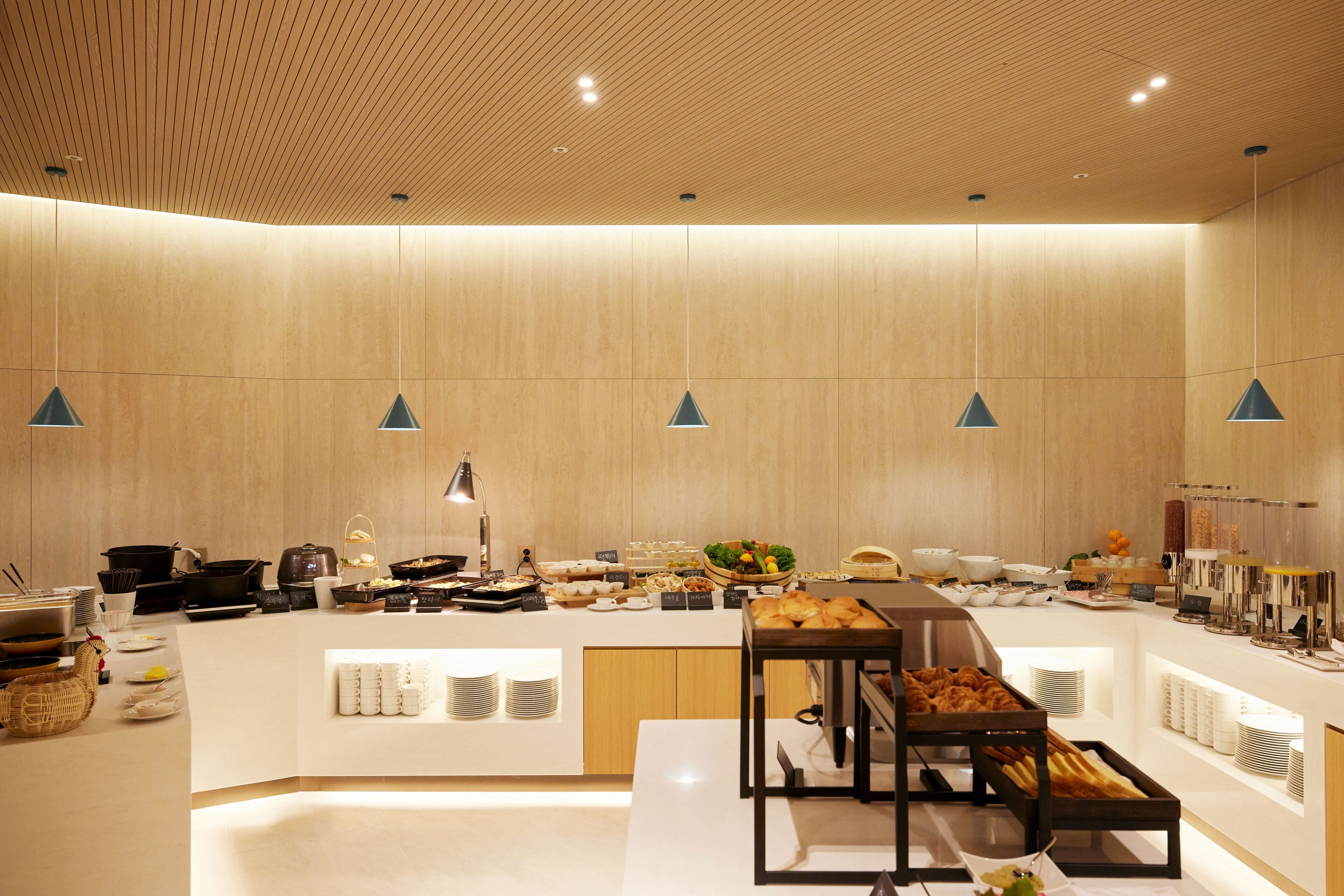 Una cucina moderna con rivestimenti in legno, un'isola centrale con lavello e diversi cibi esposti sul bancone.