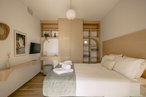 A modern bedroom with a large bed, a TV, a wooden wardrobe, and a bedside table.