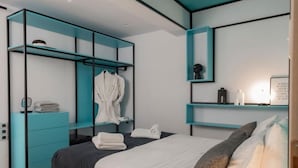 Une chambre moderne comprenant un lit, une armoire et un espace bureau.