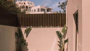 Une piscine à l’eau d’un bleu limpide, entourée d’un petit muret et agrémentée de plantes en pot.