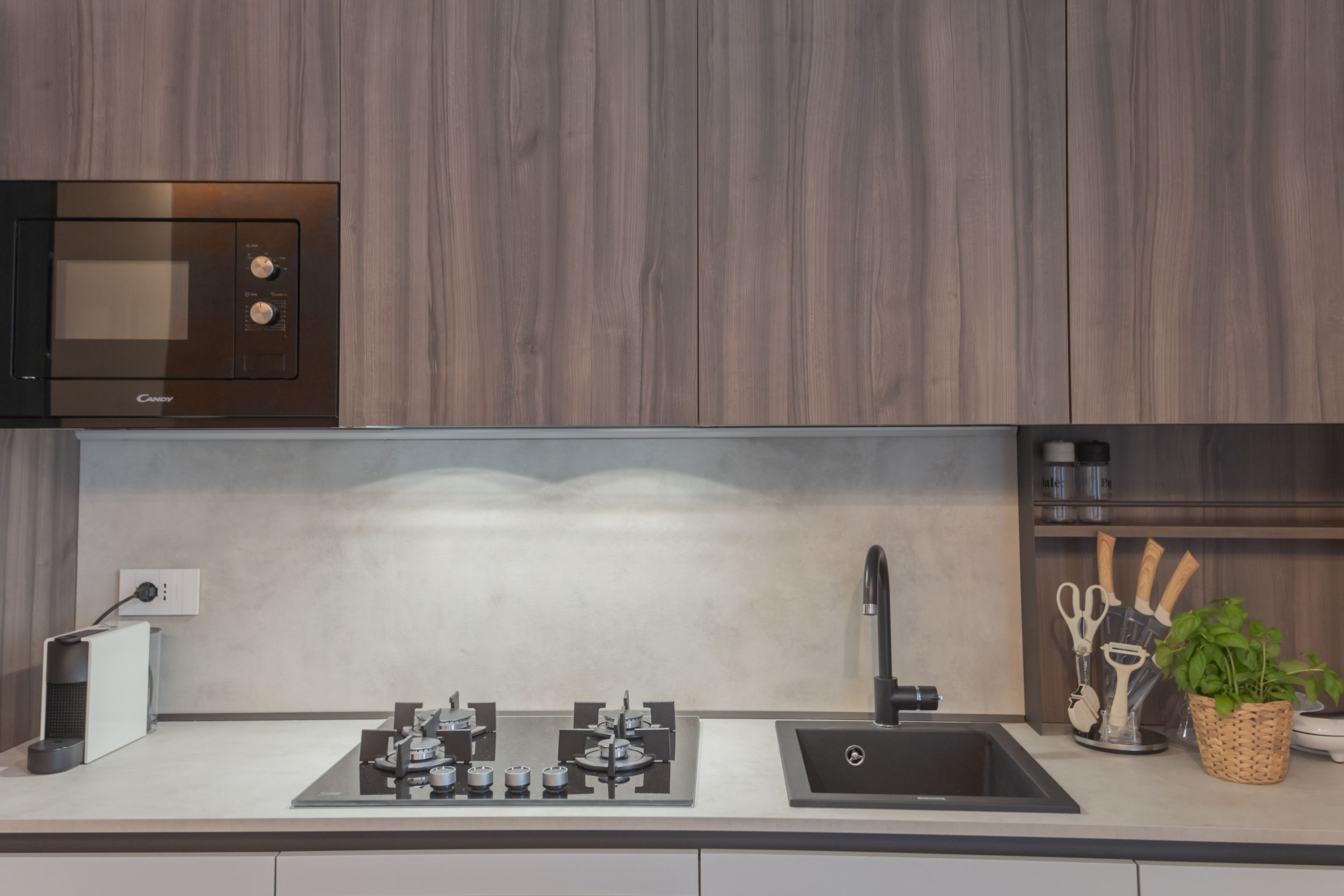 A modern kitchen with a built-in microwave, gas stove, and sink.