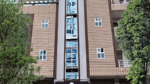 A hotel building with a central arched window, multiple balconies, and a sign reading "HOTEL PANCHVATI". - Hotel Panchvati (Malangawa)