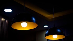Two pendant lights with a yellowish glow against a dark ceiling. - Hotel Panchvati (Malangawa)