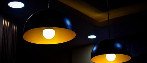 Dos lámparas colgantes con un brillo amarillento sobre un techo oscuro.