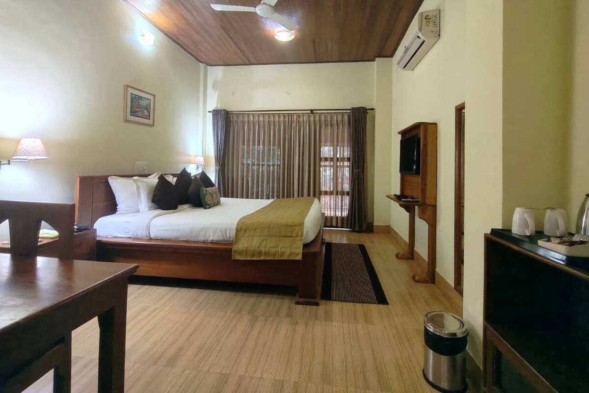 A hotel room with a bed, a desk, a TV, and a coffee maker.