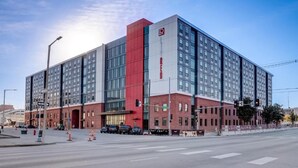 A multi-story hotel with a prominent red and gray facade, large windows, and a visible entrance. - Stay on M Street (Lincoln)