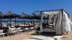 A beach with sun loungers, a cabana, and umbrellas. - Bungalow Avec Solarium à 5mn des Plages (Gran Alacant)