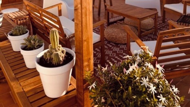 A rooftop terrace with wooden furniture, white cushions, and potted plants. - Bungalow Avec Solarium à 5mn des Plages (Gran Alacant)