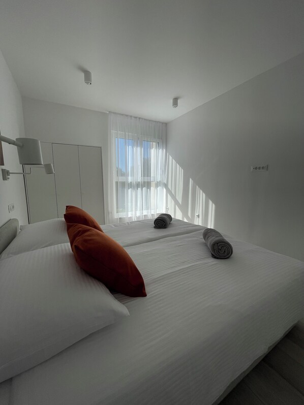 A modern hotel room with a large bed, two pillows, a window with sheer curtains, and a ceiling light fixture. -  Point of Life 2 by Litto (Split)