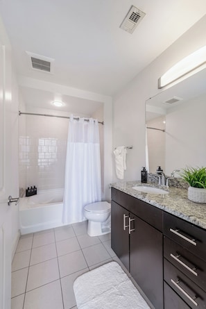 Une salle de bain moderne équipée d’une baignoire, de toilettes et d’un lavabo.