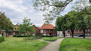 Een woonwijk met een verhard pad, groene gazons en huizen met rode pannendaken.