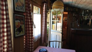 A cozy dining area with a checkered tablecloth, a blue bowl, and a wooden chair. - Maison Familiale de Charme (Lège-Cap-Ferret)