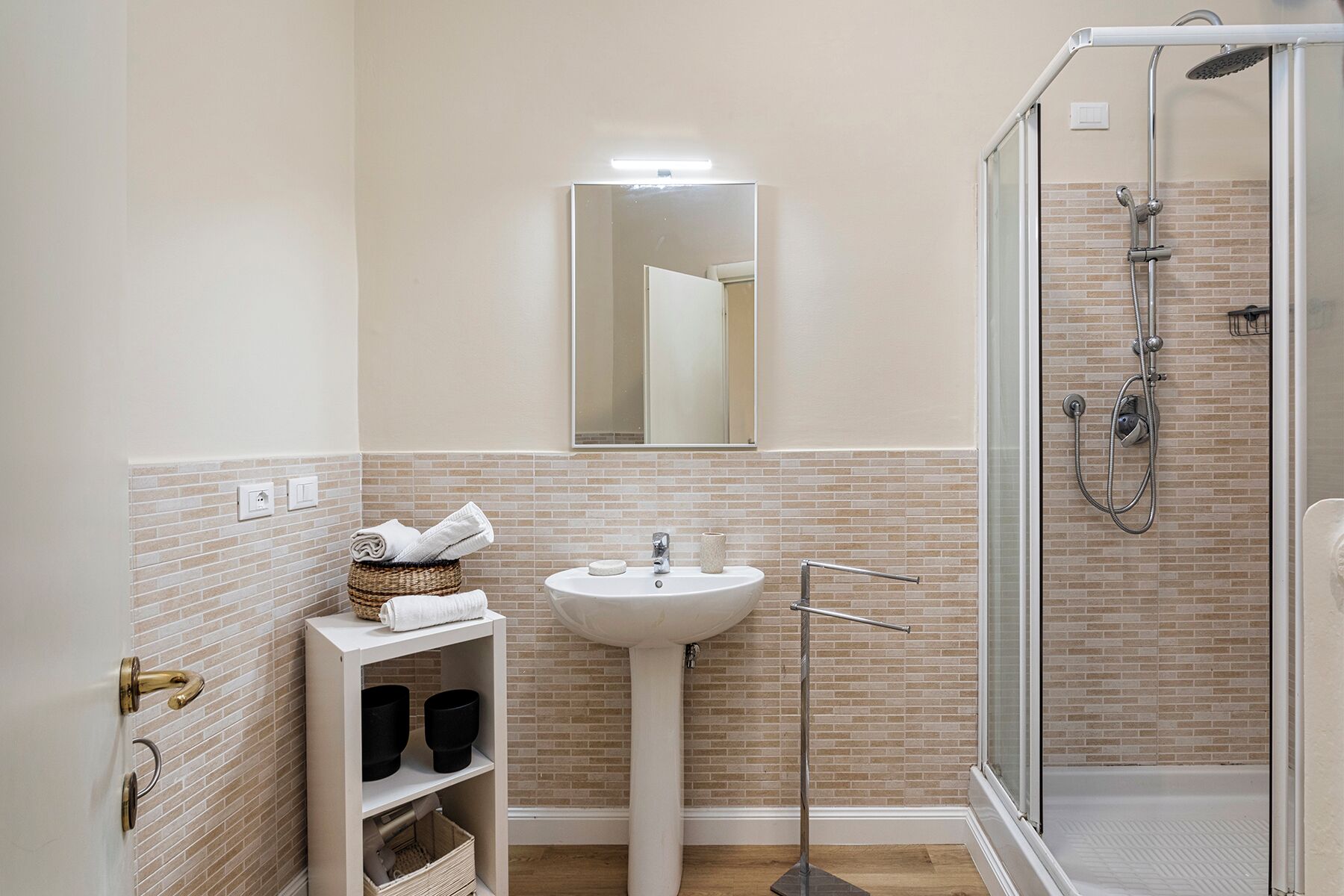 Une salle de bain avec un lavabo, un miroir et une douche.