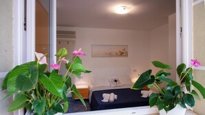 A hotel room with a bed, a nightstand, a potted plant, and a painting on the wall. - Souvenir 7 - Two Bedroom Apartment, Sleeps 6 (Gabicce Mare)