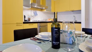 Ein Esstisch mit einer Flasche Olarice Chardonnay, Tellern und Gläsern.