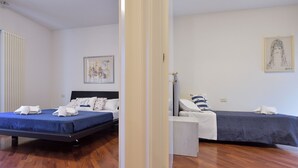 Ein Hotelzimmer mit zwei Betten, einem kleinen Tisch und Bildern an den Wänden.