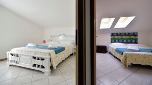 Une chambre d’hôtel avec deux lits, une grande fenêtre et un panneau décoratif au mur.