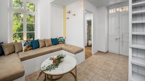 A modern living room with a beige sectional sofa, a marble coffee table, and a chandelier. - House in Symi with sea view (Simi)