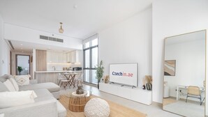 A modern living room with a sofa, coffee table, and a TV mounted on the wall. - Czechin - LIV Residence (Dubai)