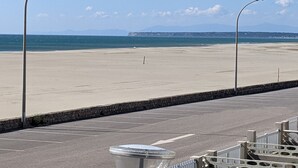 A beach with a parking area and street lamps. - Modern T2 in Port-la-Nouvelle - 4/5p - Parking - Seafront (Port-la-Nouvelle)