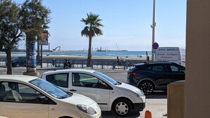 Ein Parkplatz mit Autos, einem Strand und einem Schild für einen Sanitärservice.
