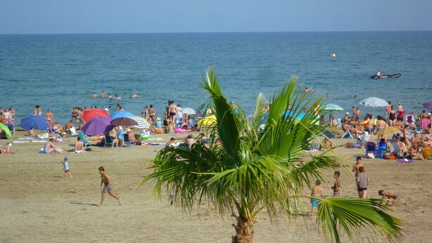 A crowded beach with people sunbathing and swimming. - Air-conditioned T2 apartment with parking, near the beach, sleeps 5 (Port-la-Nouvelle)