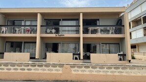 A multi-story hotel with balconies, a name sign 'Le Neptune', and a view of the street. - Air-conditioned T2 apartment with parking, near the beach, sleeps 5 (Port-la-Nouvelle)
